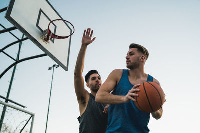 Low angle view of man playing basketball hoop against sky