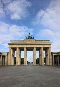 Brandenburg gate against cloudy sky during sunrise