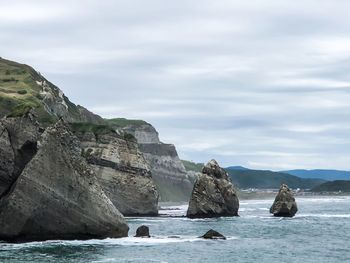 Rocks on sea shore against sky