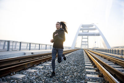 Full length of woman standing on railroad track