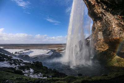 Scenic view of waterfall against sky