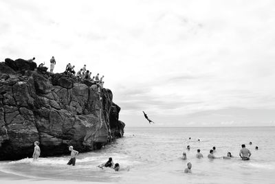 People enjoying in sea against sky