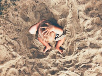 High angle view of woman lying on sand
