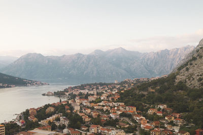 Aerial view of townscape and mountains against sky