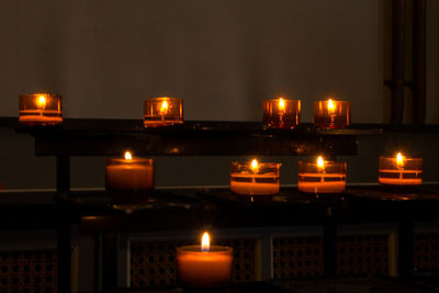 Close-up of illuminated candles against sky at night
