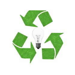Green light bulb against white wall
