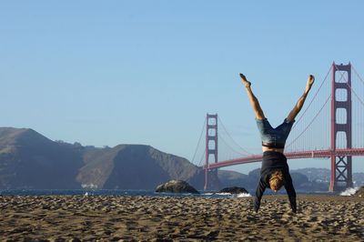 Boy on beach against clear sky
