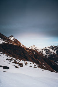 Scenic view of snow covered mountains against sky