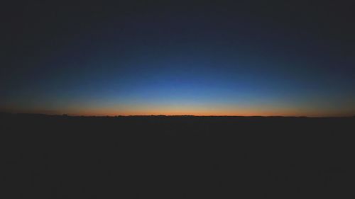 Silhouette landscape against clear sky during sunset