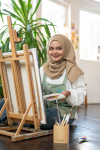 Portrait of young woman sitting on table