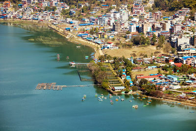 High angle view of boats in sea against buildings in city