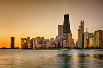 View of city at waterfront during sunset