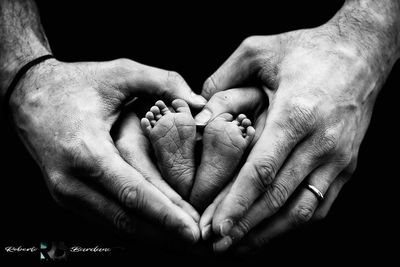 Close-up of man holding baby hand