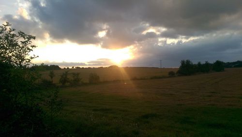 Scenic view of grassy field against cloudy sky