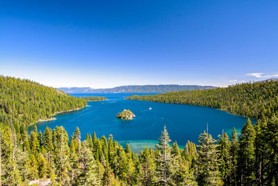 Scenic view of lake and trees against blue sky