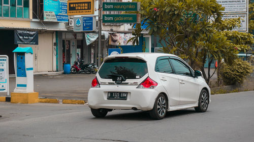 Car on street against buildings in city