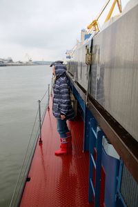 Man standing in boat deck over sea