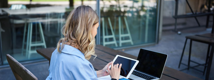 Young woman using laptop at cafe