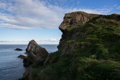 Close-up of rock by sea against sky