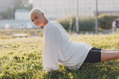 Side view of man sitting on grassy field