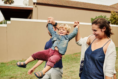 Parents holding son mid air outdoors