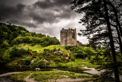 Castle by trees against sky