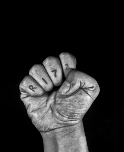 Close-up of human hand against black background