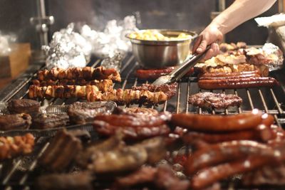 Person preparing food on barbecue grill