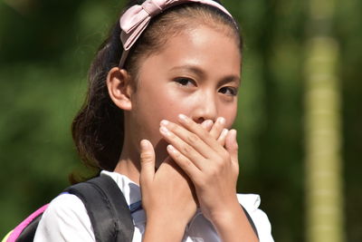 Close-up portrait of smiling girl standing outdoors