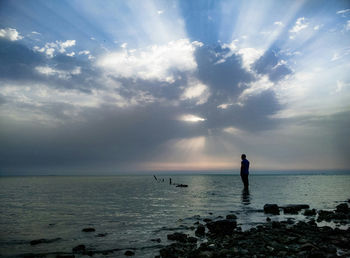 Men in sea against sky