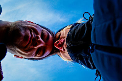 Directly below portrait of man and woman standing against sky