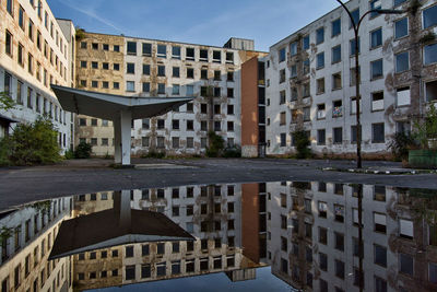 Buildings by canal against sky in city