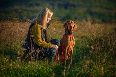 Mature woman walking her beautiful vizsla. dog walking background. woman and dog enjoying walk.