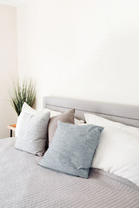Tilt image of headboard with grey pillows and copy space