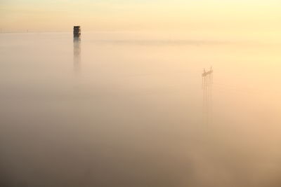 Electric station pipe and pylon in strong fog