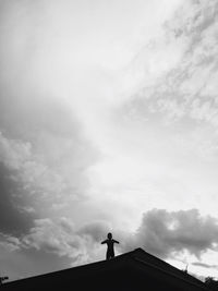Low angle view of silhouette people standing against sky