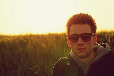 Portrait of man at field against sky during sunset