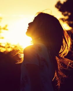 Rear view of woman looking at sunset