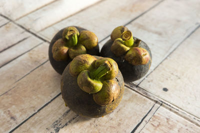 Close up image of purple mangosteen on a wooden background.