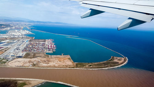 Aerial view of sea and cityscape against sky