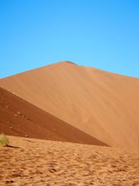 Scenic view of desert against clear blue sky