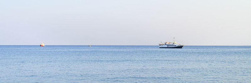 Sailboat sailing on sea against clear sky