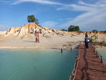 People on shore against sky