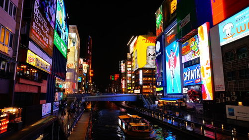 High angle view of ferry sailing in canal amidst illuminated buildings