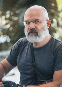 Portrait of a bald man with a gray beard. a middle-aged man looks at camera