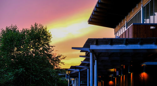 Low angle view of illuminated building against sky at sunset