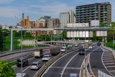 High angle view of vehicles on road by buildings in city