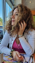 Close-up of beautiful woman looking away while sitting at restaurant