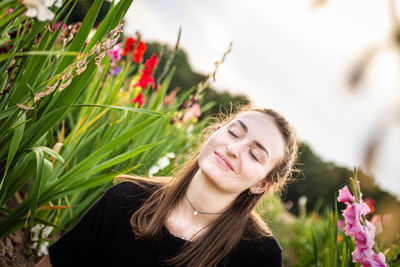 Portrait of a smiling young woman against plants