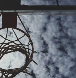 Low angle view of basketball hoop against cloudy sky